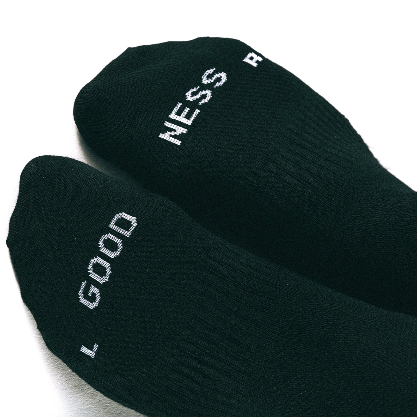 merino socks, flatlay, schwarze merino socken, cycling socken, made in germany, stricksocke, schwarz mit weisser schrift